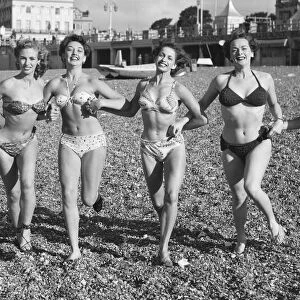 Friends ejoying the early spring sunshine on Brighton beach. Circa April 1952