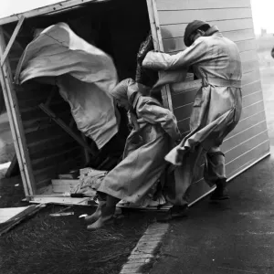Gale damage. A couple cling desperately to their overturned beach hut at Littlehampton to Gale damage. A couple cling desperately to their overturned beach hut at Littlehampton to