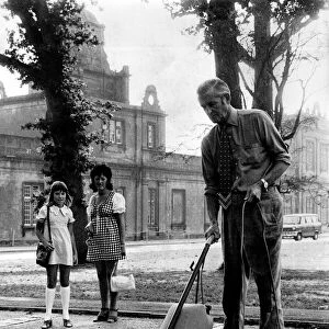 Most gardeners would use a lawn mower. But the man in the patched trousers is a cut above
