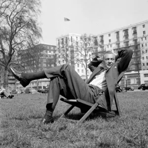 Gary Cooper sitting on a deck chair in London - April 1955 English flag in Gary Cooper sitting on a deck chair in London - April 1955 English flag in