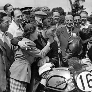 Geoff Duke (the winner) receives a congratulatory kiss from his wife Pat while the 2nd H