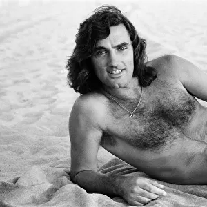 George Best relaxing at Hermosa Beach, Los Angeles, California. 25th July 1977