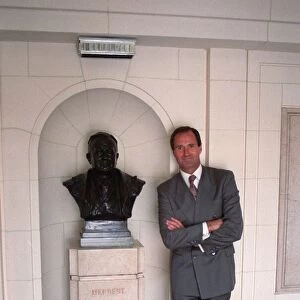 George Graham former Arsenal manager next to a bust of Herbert Chapman in marble hall of