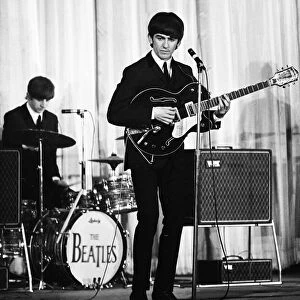 George Harrison of the Beatles performing on stage November 1964