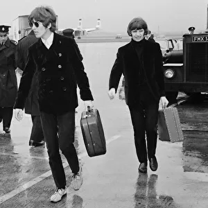 George Harrison and Ringo Starr leave a rainsoaked London Airport for Chicago via Boston