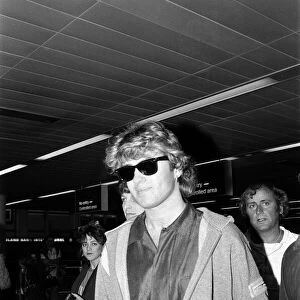 George Michael of the pop group Wham!, arriving at Gatwick airport on his return