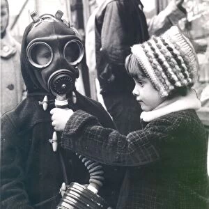 George Sizeland wears a World War Two gas mask as his sister, Marie, looks on. circa 1939