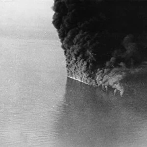 A German tanker ablaze to the water line after an attack by RAF Coastal Command in