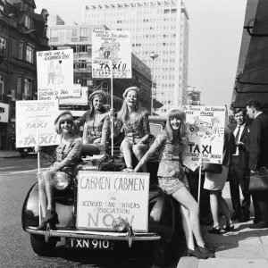 Four girls wearing mini skirts pose on the front of a taxi cab as part of a campaign