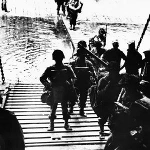 GI.s (with equipment) entering landing craft during WWII. 6th June 1944 GI.s (with equipment) entering landing craft during WWII. 6th June 1944
