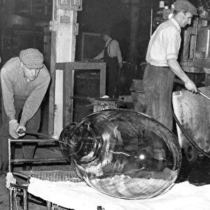 Glass is being taken away to cool after being extracted from the mould in March 1965