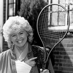Gloria Hunniford TV Presenter holding the tennis racket she was useing when she broke her