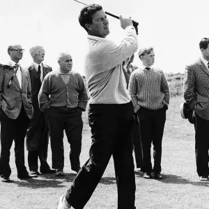 Golfer Peter Thomson playing from the fairway to the 13th hole in front of small group of Golfer Peter Thomson playing from the fairway to the 13th hole in front of small group of