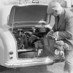 Golfer seen here storing his golf clubs in the boot of his brand new Standard 8 car Circa Golfer seen here storing his golf clubs in the boot of his brand new Standard 8 car Circa