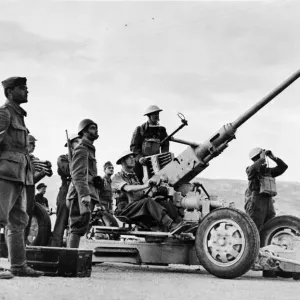 Greek soldiers stand by an a gun, manned by British soldiers