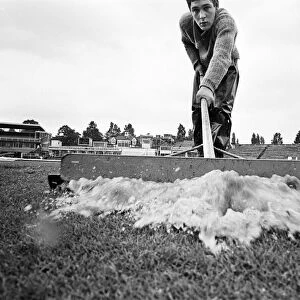 Groundsman Ian Guys tries to clear the water from the pitch at Edgbaston ahead of