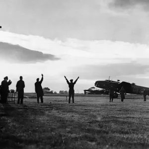 The group captain commanding officer of an RAF station signals a Halifax bomber to begin The group captain commanding officer of an RAF station signals a Halifax bomber to begin