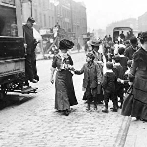 A group of children a female tram passenger for her used ticket after she descended