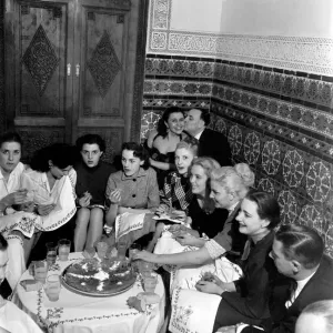 Un gruppo di amici si è riunito intorno a un tavolo godendosi dei drink in una serata fuori a Marrakech. Un gruppo di amici si è riunito intorno a un tavolo godendosi dei drink in una serata fuori a Marrakech.