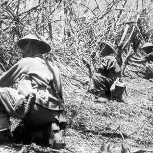 Gurkha soldiers in position cut bamboo stakes to protect their newly won positions during