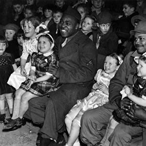 Happy picture of the children with black American soldiers enjoying a programme of
