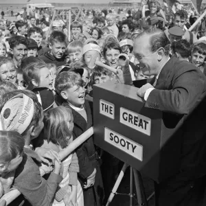Harry Corbett and Sooty mobbed by fans at the Daily Mirror Beach party. August 1958
