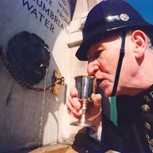 Harry Wynne dressed as a police sergeant from 1913 takes a drink from the newly installed