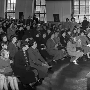 Black and white print of a senior school head teacher speaking to parents