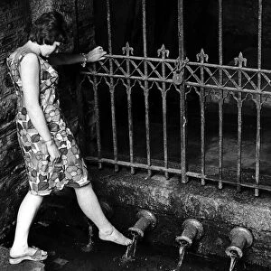 Heather Doney wets her foot at the pipe well in Well Lane at Liskeard, Cornwall