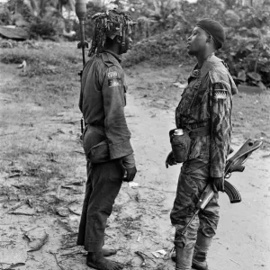 Two heavily armed Biafran soldiers seen here talking to each other during the Biafran Two heavily armed Biafran soldiers seen here talking to each other during the Biafran