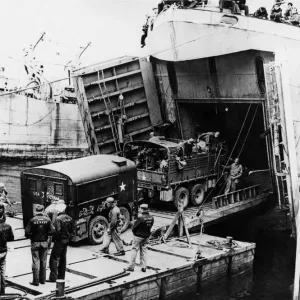 A heavy truck pulls a field kitchen up the bow ramp of an LST (Landing Ship Tank A heavy truck pulls a field kitchen up the bow ramp of an LST (Landing Ship Tank