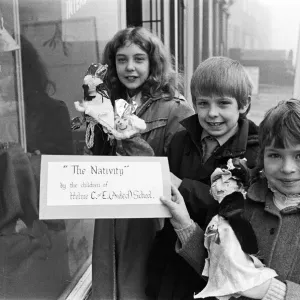 Helme Junior School pupils arranging their Nativity scene in the window of a Meltham Helme Junior School pupils arranging their Nativity scene in the window of a Meltham