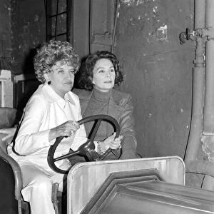 Hermione Gingold (L) and Jean Simmons (R) in a stage prop car at the Adelphi Theatre