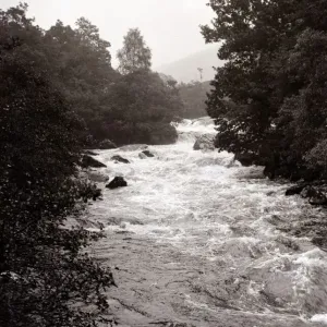 A highland river in full flow, after the snow has melted from the high mountains