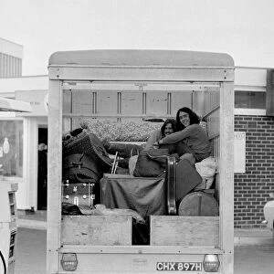 Two hitch-hikers getting a comfortable lift in the back of a truck September 1970
