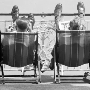 Holiday scenes at Brighton Two holidaymakers put their feet up on Brighton Holiday scenes at Brighton Two holidaymakers put their feet up on Brighton