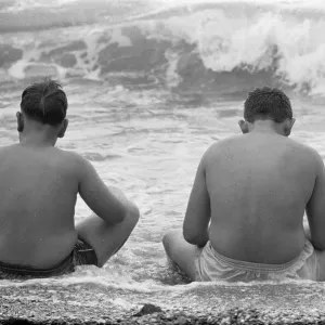 Holiday scenes at Brighton To young boys sitting in the sea to cool off during Holiday scenes at Brighton To young boys sitting in the sea to cool off during