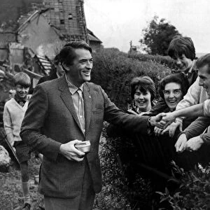 Hollywood filmstar Gregory Peck shakes hands with delighted residents of Crumlin on his