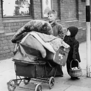 Homeless children with a pram of possessions. 22nd November 1940 Homeless children with a pram of possessions. 22nd November 1940
