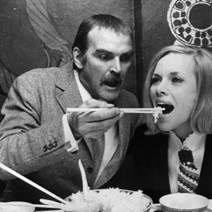 Honor Blackman and Stanley Baker eating food with chopsticks in Chinese restaurant Honor Blackman and Stanley Baker eating food with chopsticks in Chinese restaurant