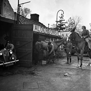 A horse being re-shoed by a blacksmith at his forge January 1948. O22134-001