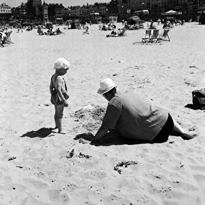 Hot weather scenes in Margate, Kent. An adult and child playing on the beach