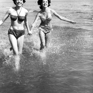Hot weather scenes in Margate, Kent. Two young women running in the sea. 30th June 1961 Hot weather scenes in Margate, Kent. Two young women running in the sea. 30th June 1961