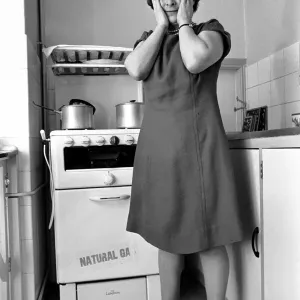 Household - Domestic Chores Cooking. A woman using her gas over in the kitchen of her Household - Domestic Chores Cooking. A woman using her gas over in the kitchen of her