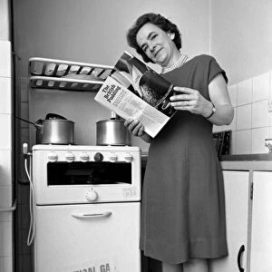 Household - Domestic Chores Cooking. A woman using her gas over in the kitchen of her