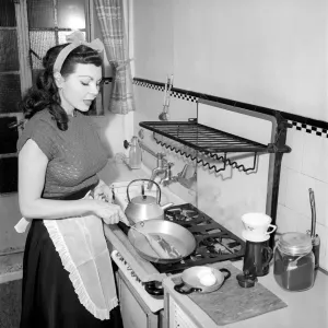 A Housewife cooking in the kitchen, 1957 A Housewife cooking in the kitchen, 1957