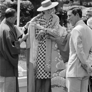 HRH Princess Diana, The Princess of Wales, is helped by city officials to wear a