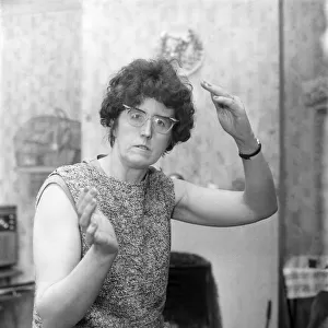 Humour: Woman wearing glasses gestures with her hands. December 1969 Z12083