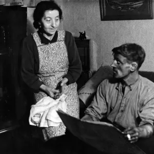 Husband Tom, home from the pit, likes a look at the paper as his wife waits to dish up Husband Tom, home from the pit, likes a look at the paper as his wife waits to dish up