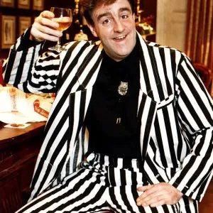 Iain McColl actor in black and white striped suit raising glass whisky toast STV Hogmanay Iain McColl actor in black and white striped suit raising glass whisky toast STV Hogmanay